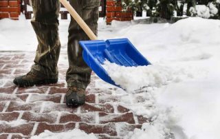 Man removing snow from the sidewalk after snowstorm. Winter work